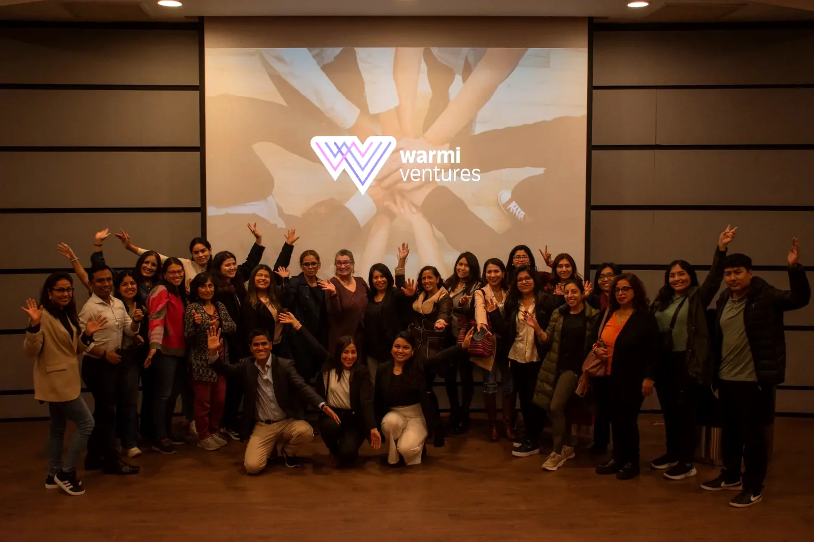 Comunidad Warmi celebrando en FemWeek con las manos en alto